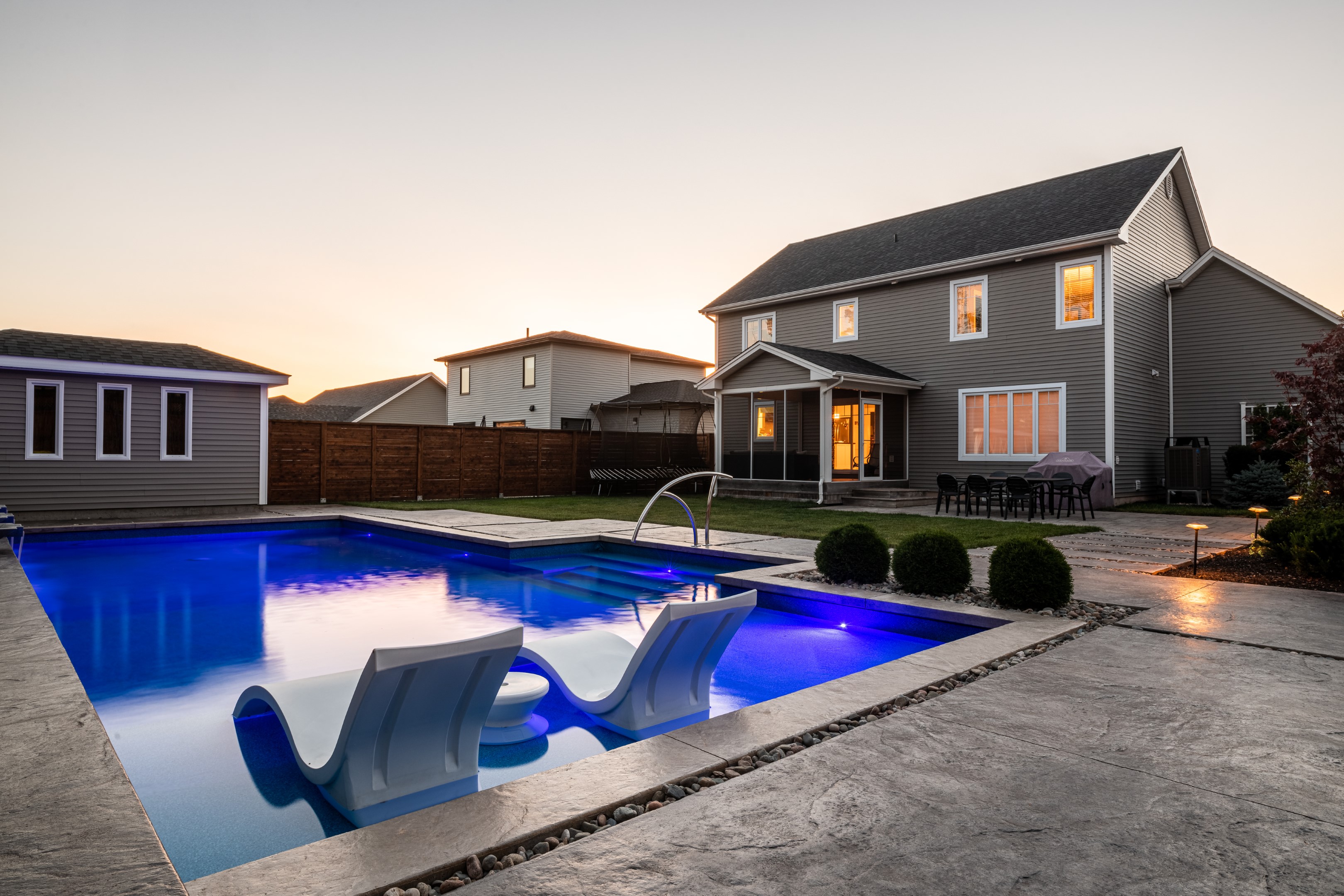 Backyard luxury pool, angled shot with home in half light