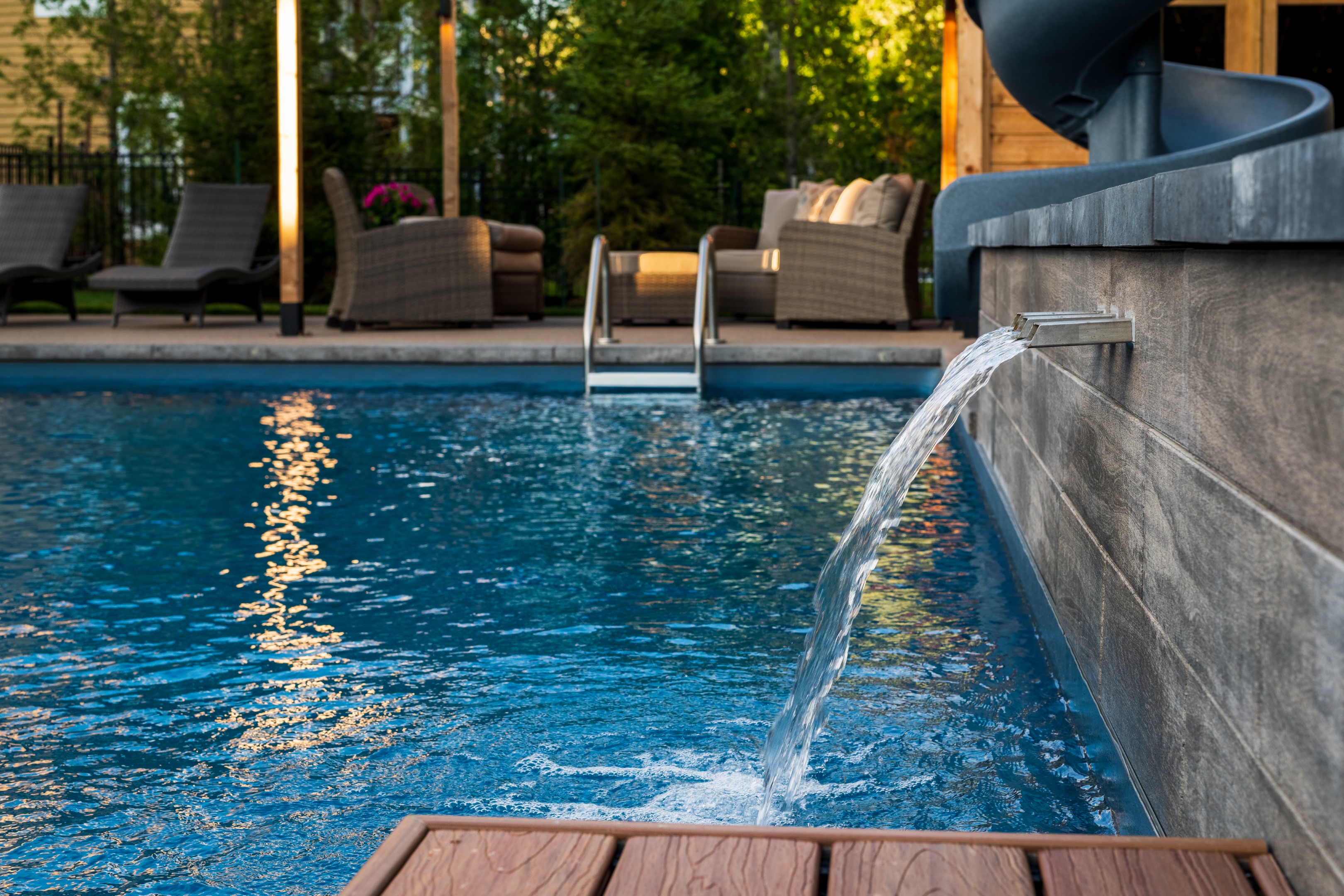 Water feature flowing into home swimming pool