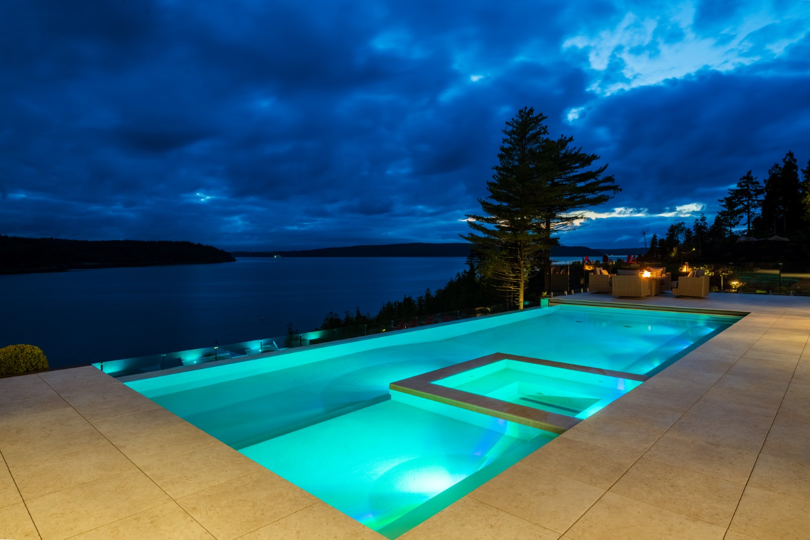 Vanishing edge pool and hot tub with underwater lighting at night in Saint John