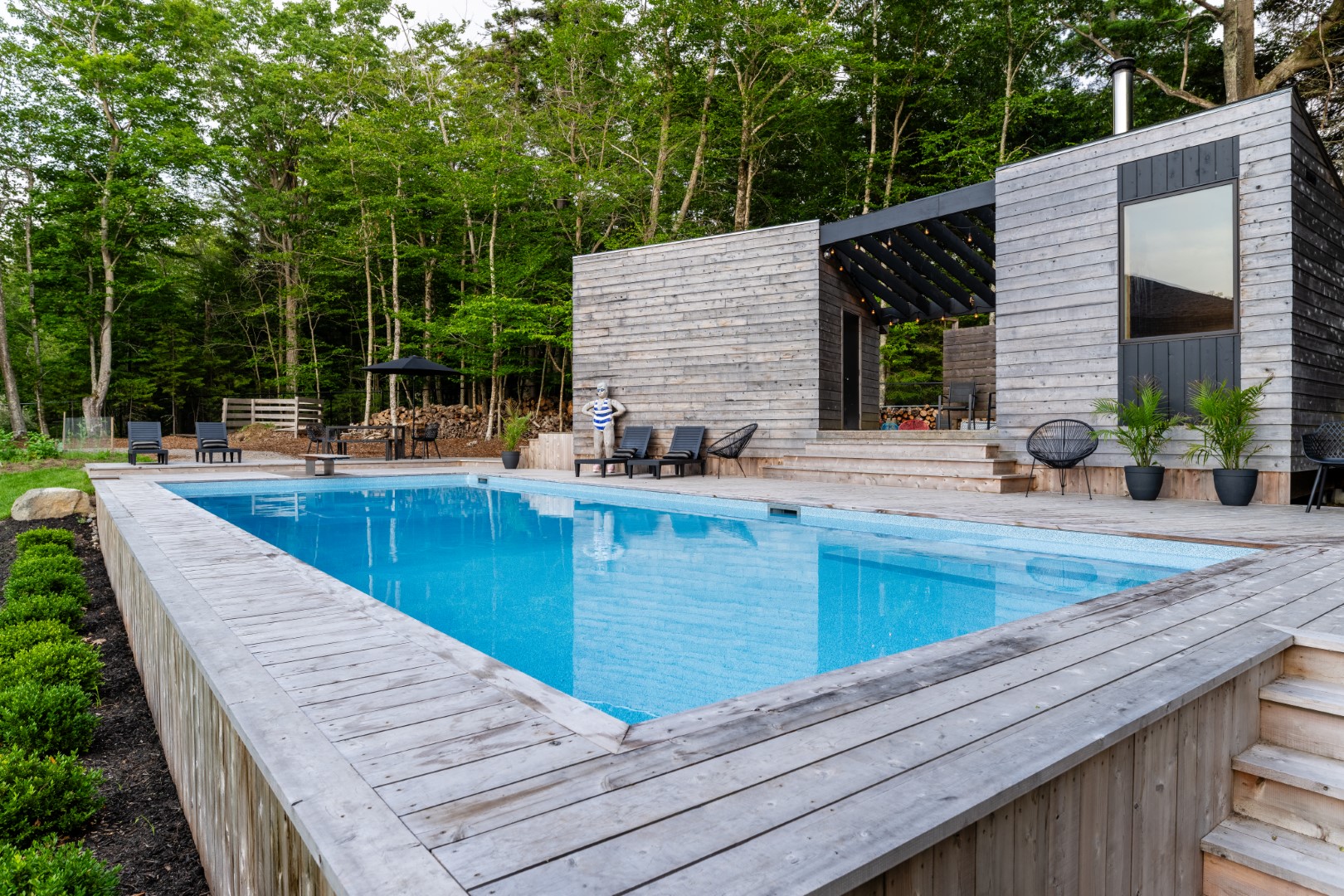 Pool with wooden diving board and modern wood patio in New Brunswick