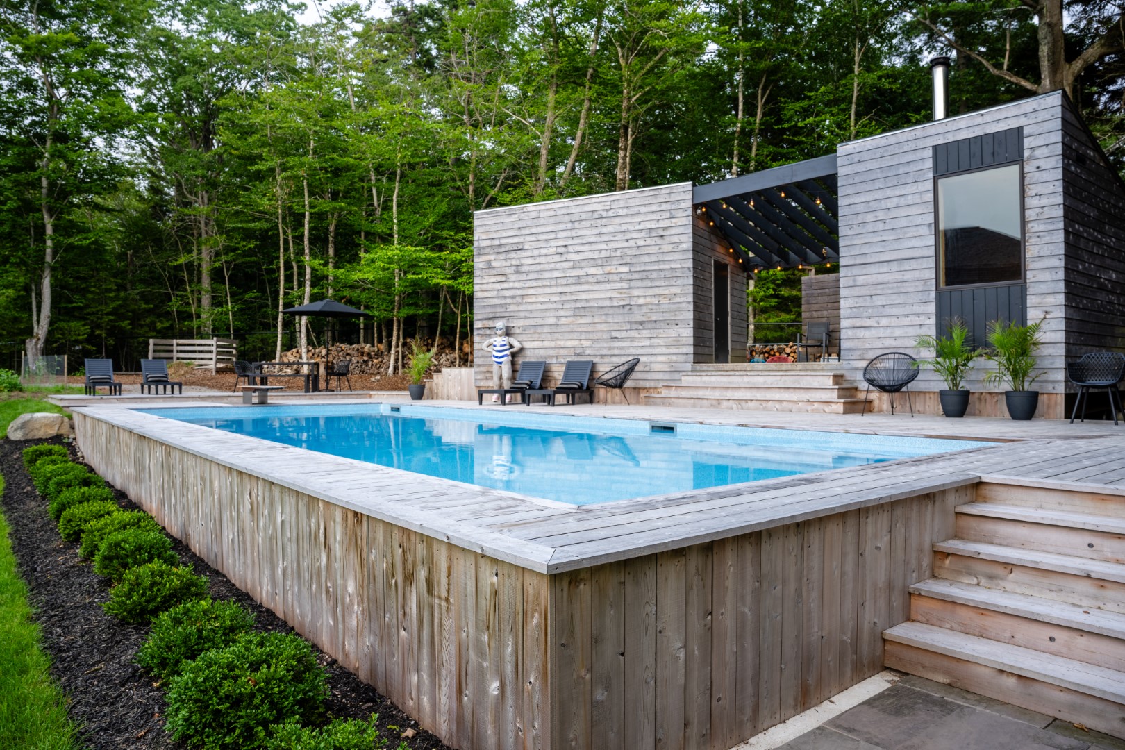 Pool with wooden diving board and modern wood patio for New Brunswick home pool