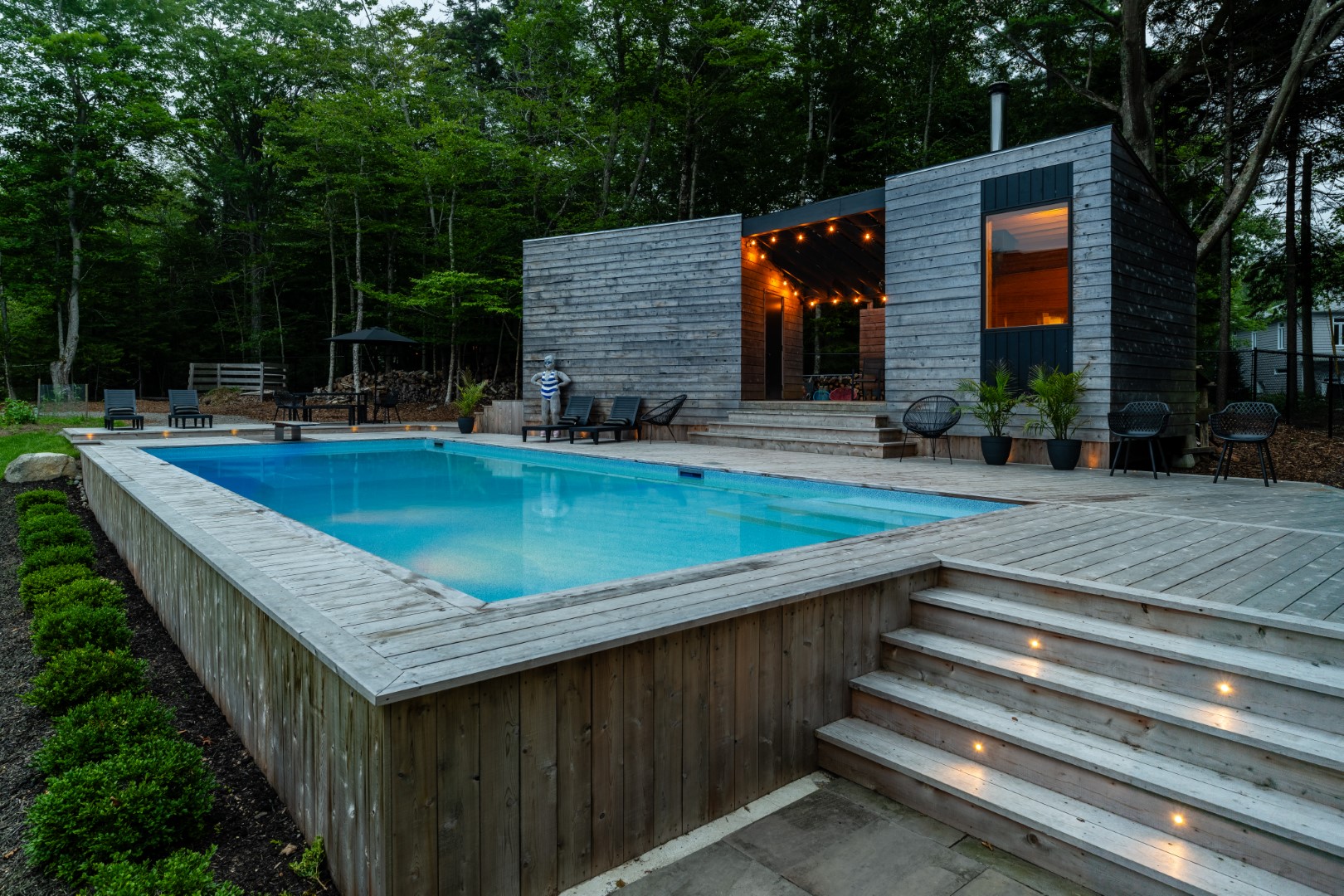 Home swimming pool with wooden diving board and wood patio installed in Rothesay, New Brunswick