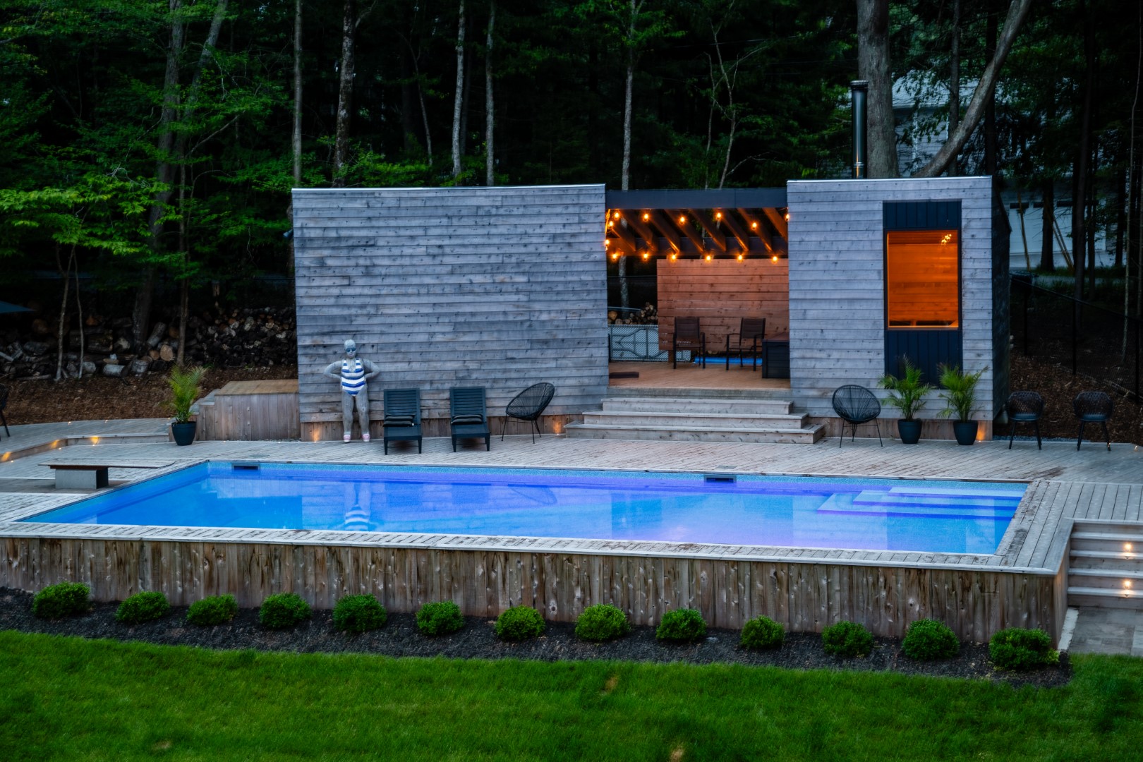 Pool and sauna building with wooden decking and wooden diving board in Rothesay