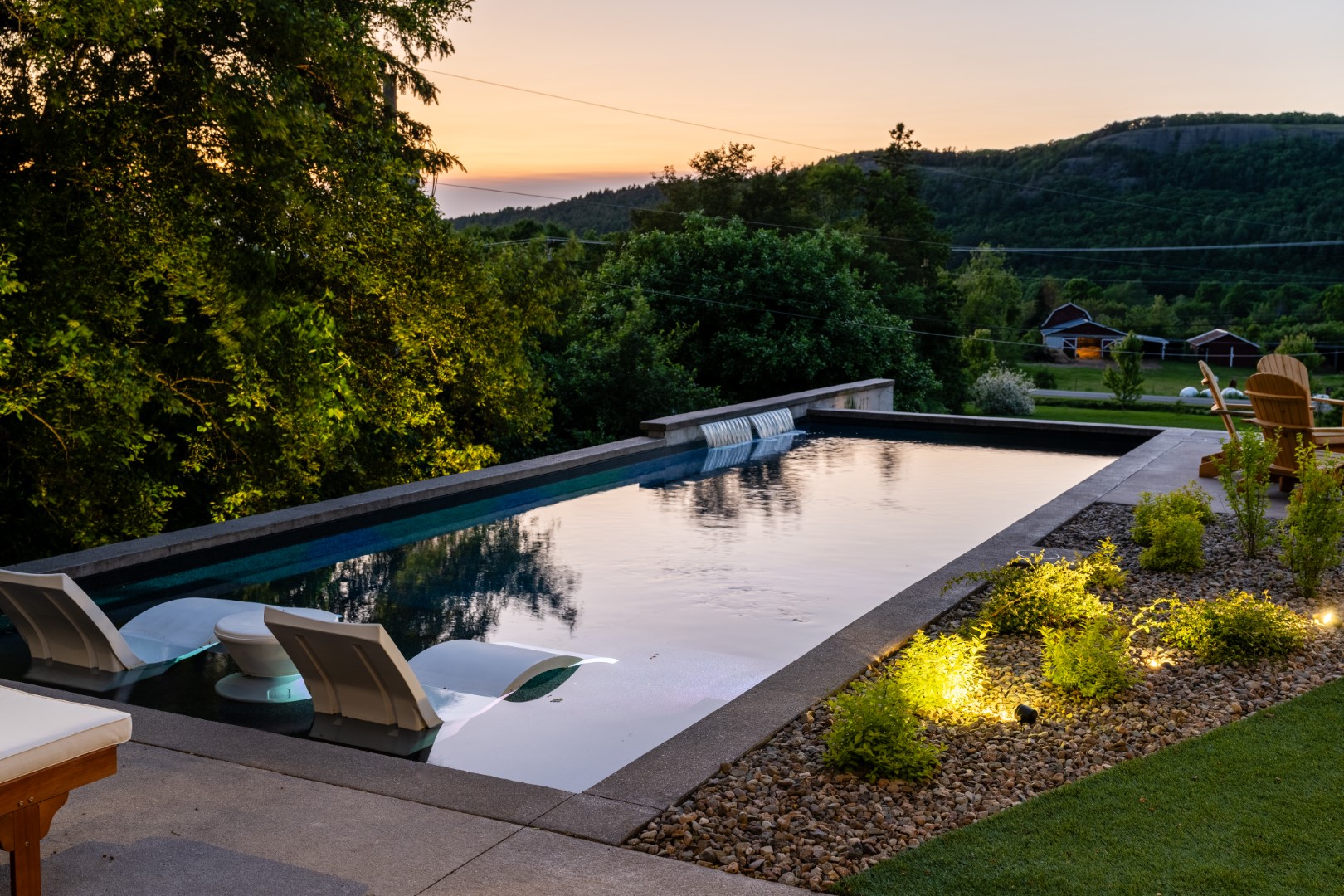 Pool with tanning ledge and water feature in Sussex