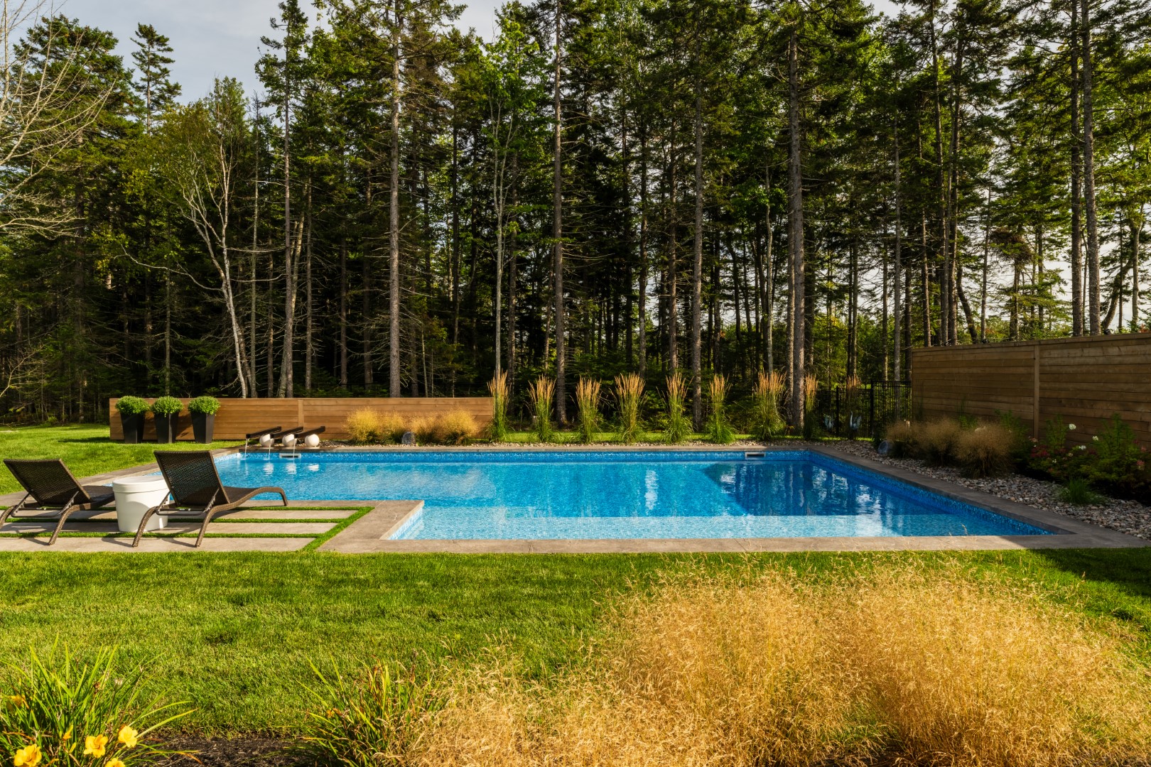 Back garden luxury pool installation with water feature in New Brunswick