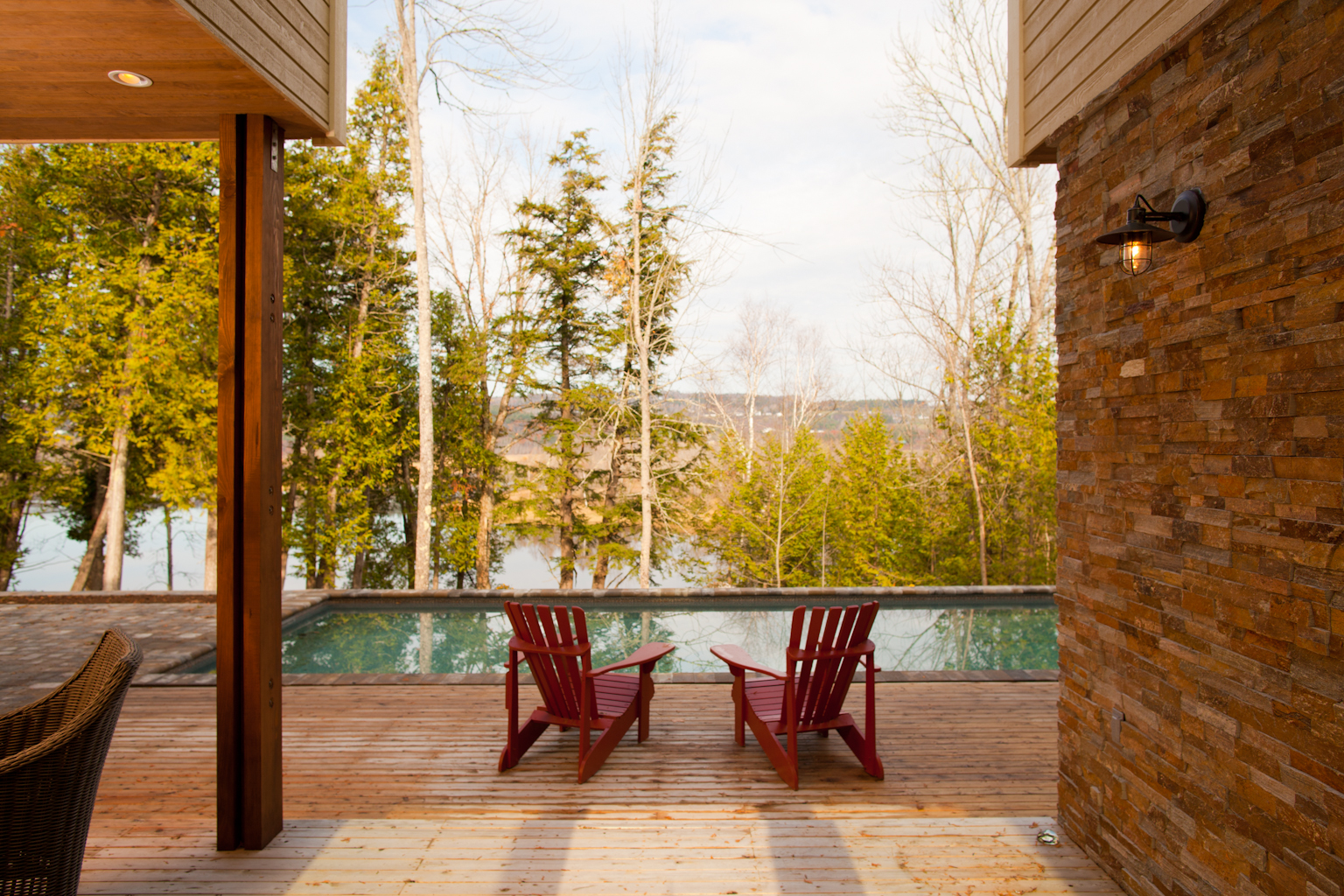 Shot showing seating area and installed home swimming pool enclosed by trees for privacy in River Run