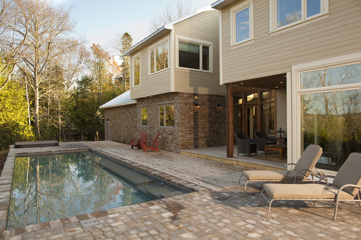 Angled shot of home with seating area, patio and home luxury swimming pool in River Run on sunny day