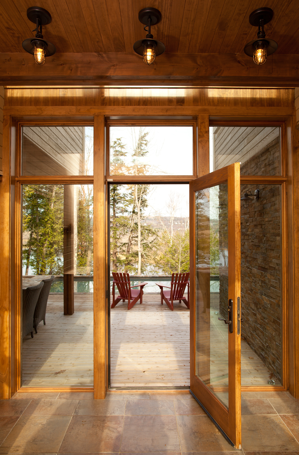 Wooden decking leading seating area and home pool in River Run home