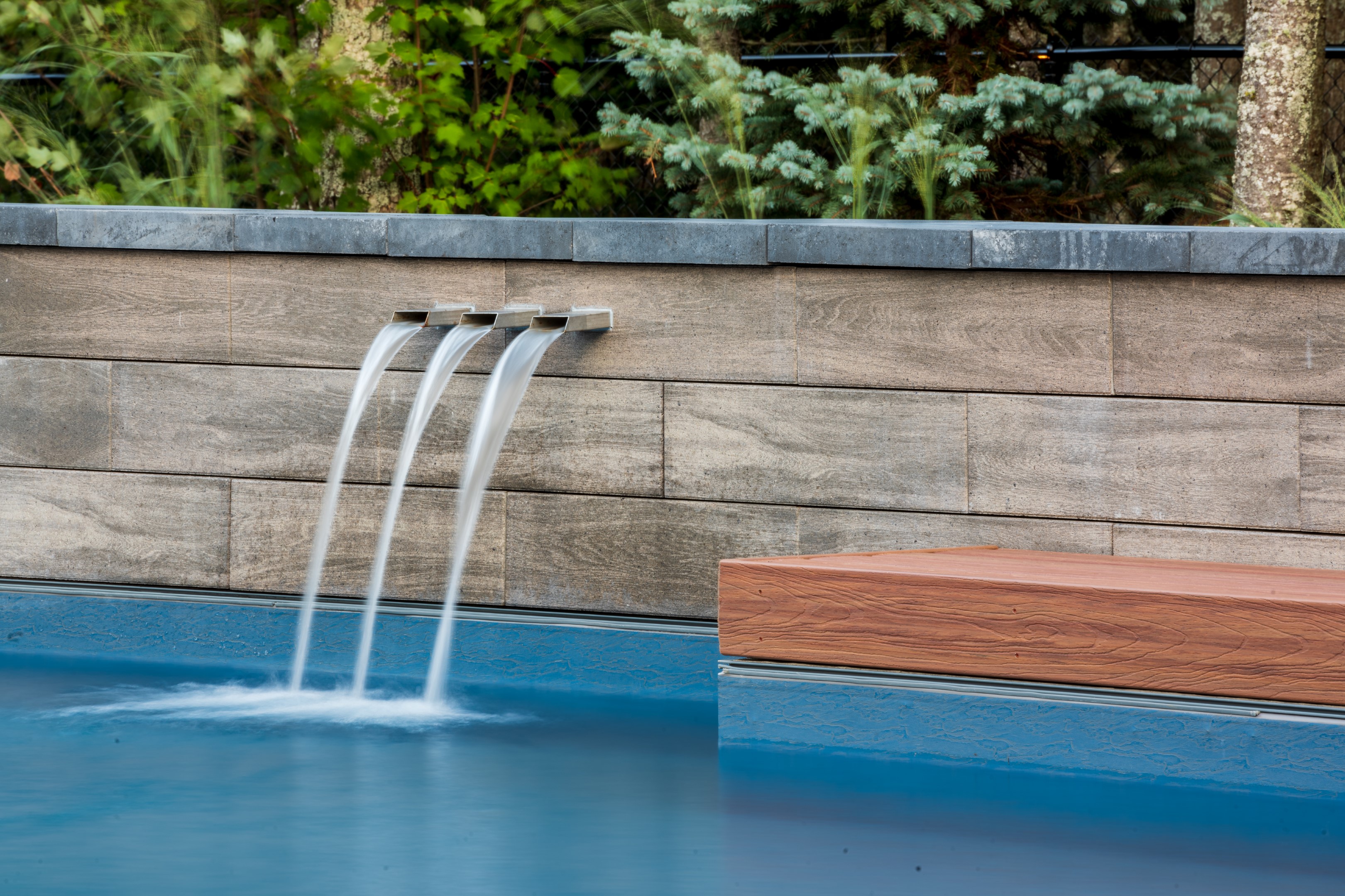 Triple water spout water feature flowing into home swimming pool in Lakeburn 