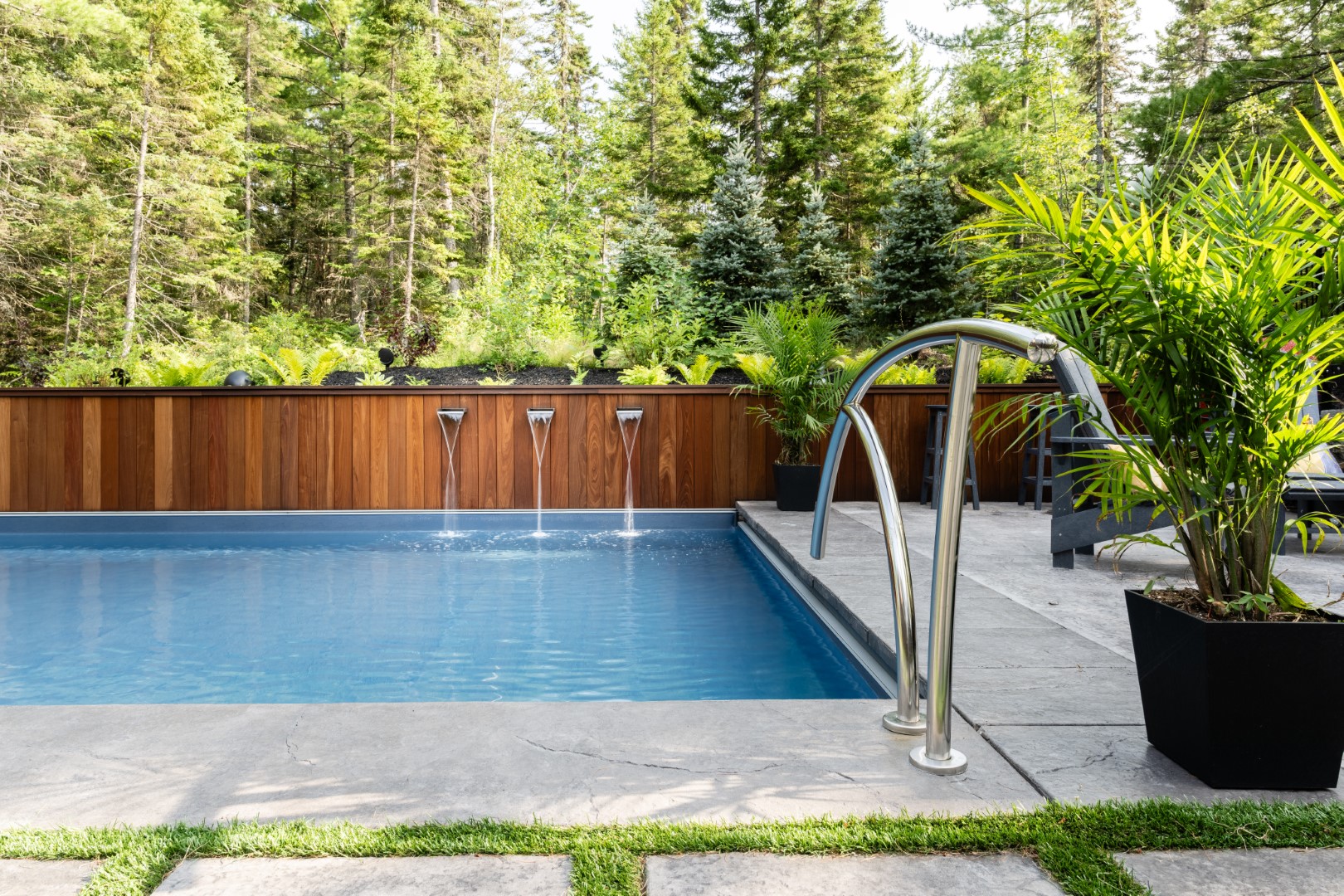 Luxury home outdoor pool with trio of waterspouts in New Brunswick