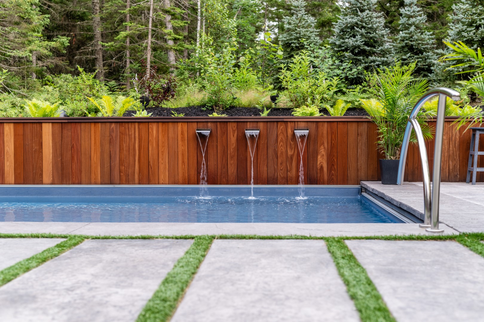 Triple water spout water feature flowing into home swimming pool in Lakeburn with a wide angle