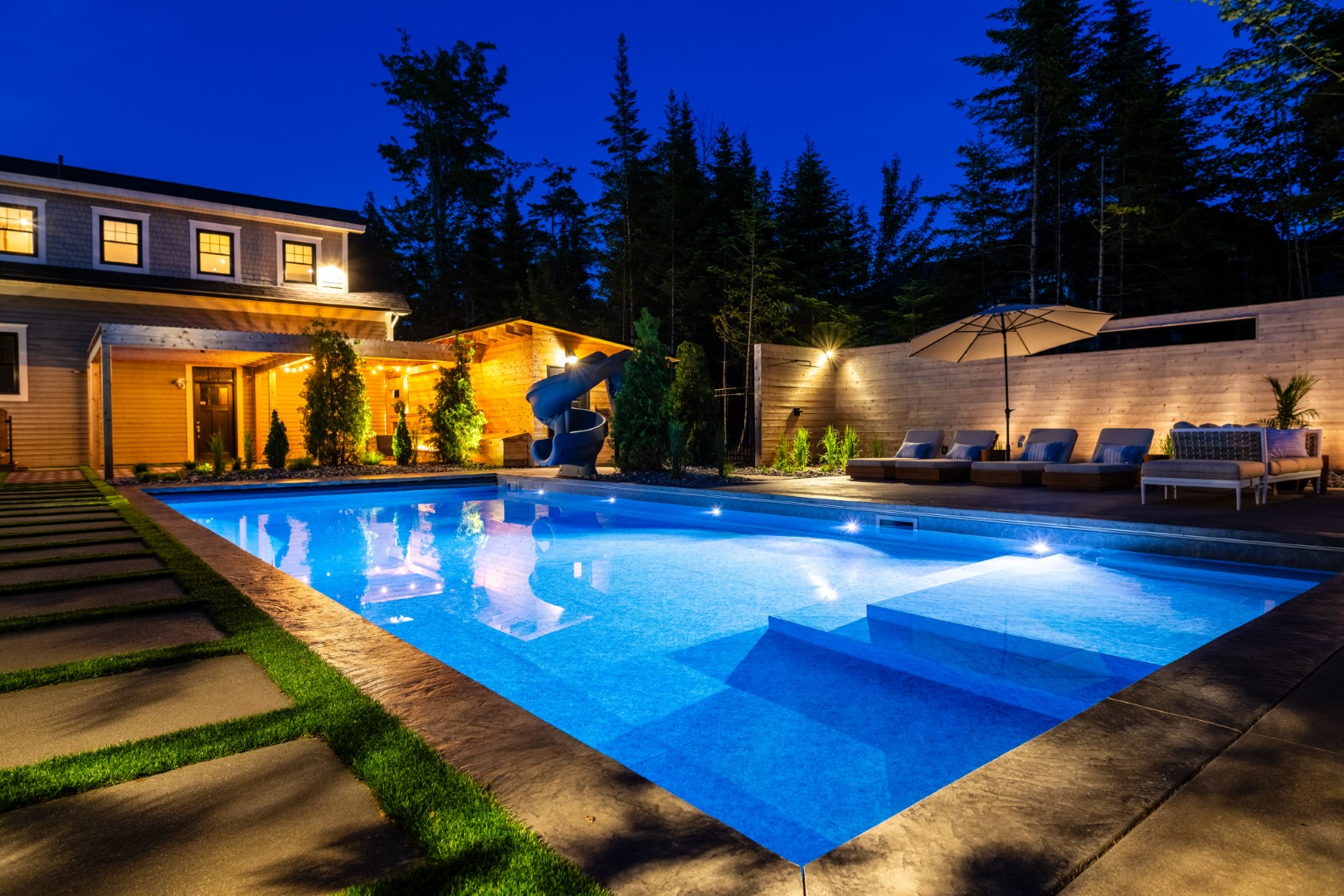 Pool and Seating area lit up at night both in garden and pool underwater lighting at Moncton residence