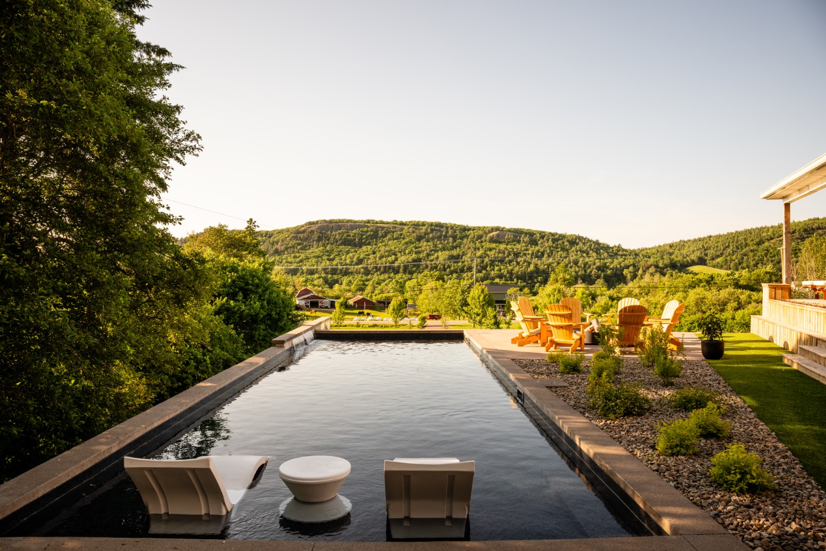 Pool with tanning ledge and water feature in Sussex from straight on view at seating area