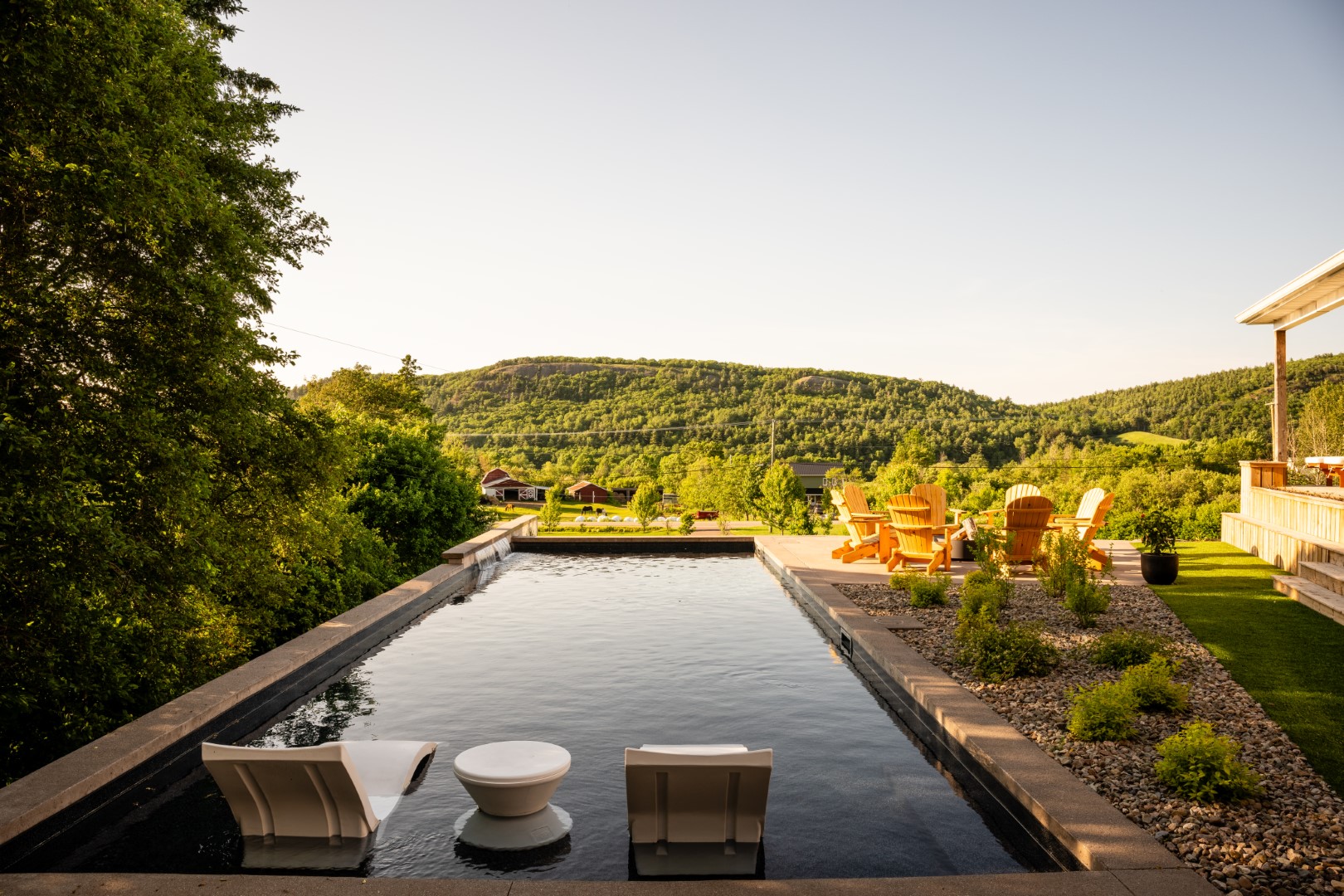 Pool with tanning ledge and water feature in Sussex from straight on view at seating area