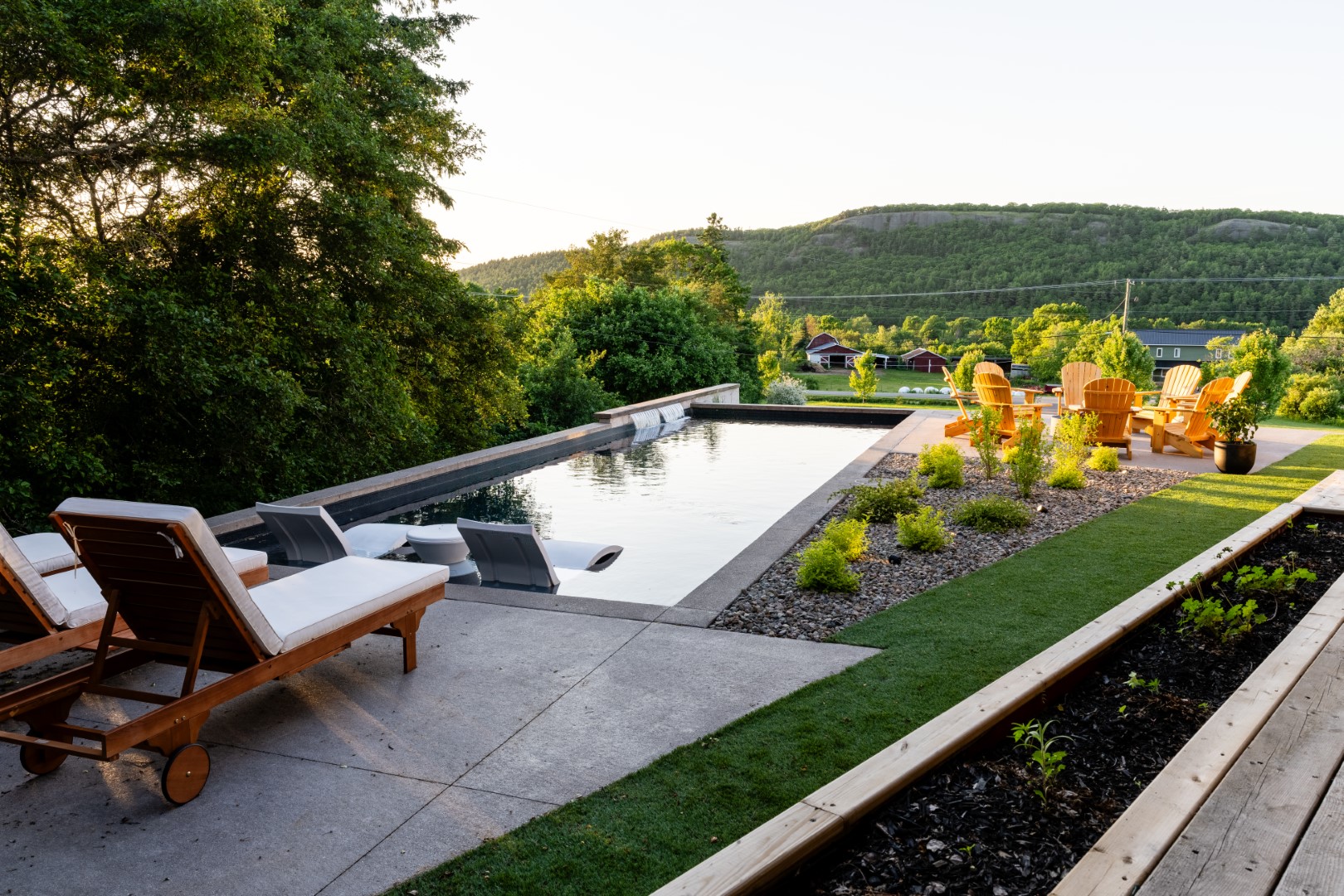 Pool with tanning ledge, hot tub and seating area in Sussex residence