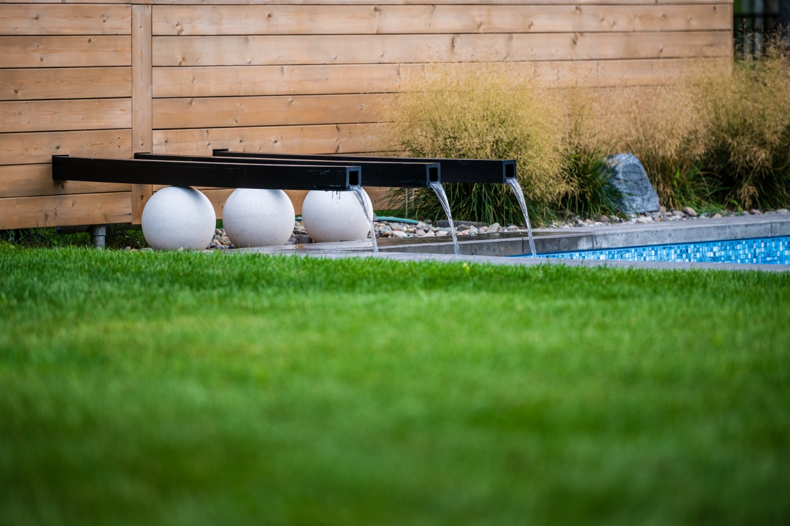 Water feature flowing into back garden swimming pool for residential client, NB