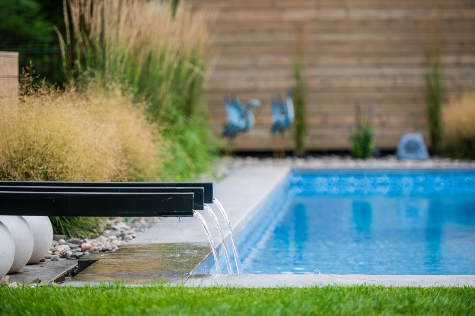 Triple water feature flowing into back garden residential swimming pool, Atlantic Canada