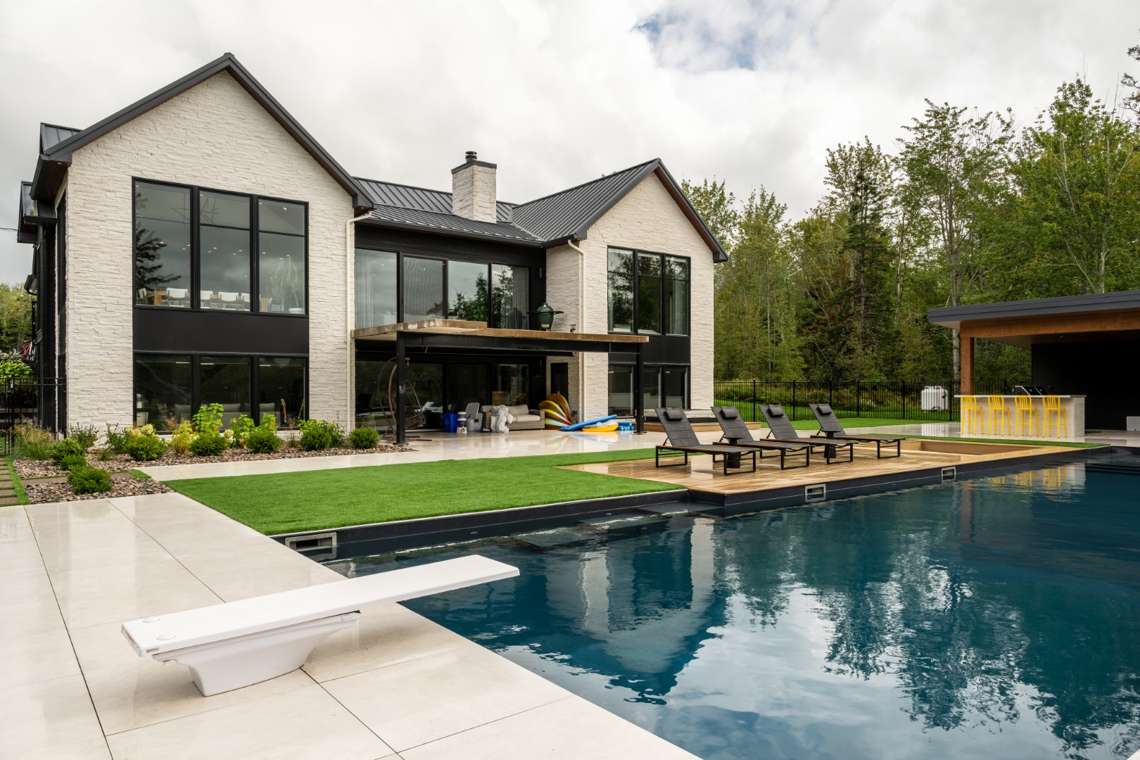 Large residential pool with tanning ledge, slide and diving board in Lakeview back garden