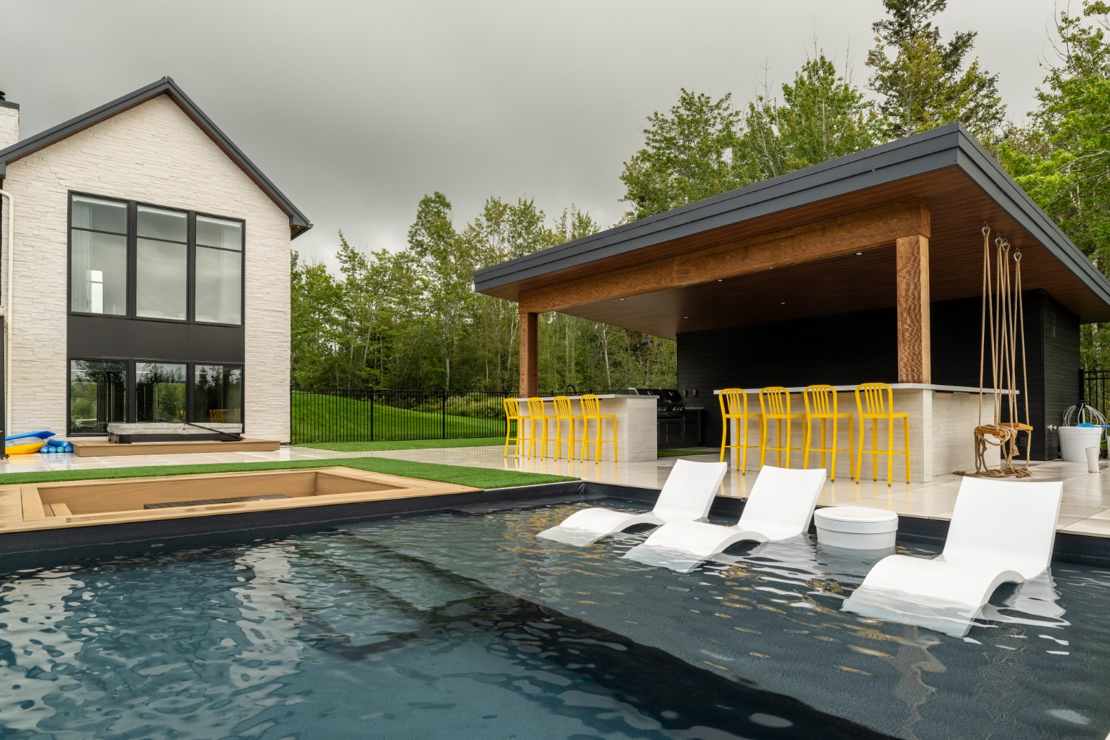 Tanning Ledge with partially covered bar area and back garden swimming pool in Lakeview