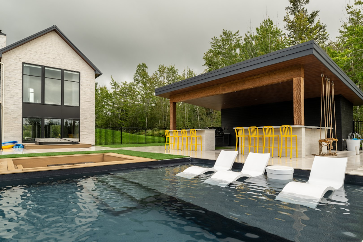 Luxury swimming pool with tanning ledge in backyard in Moncton
